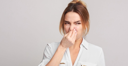 woman holding her nose